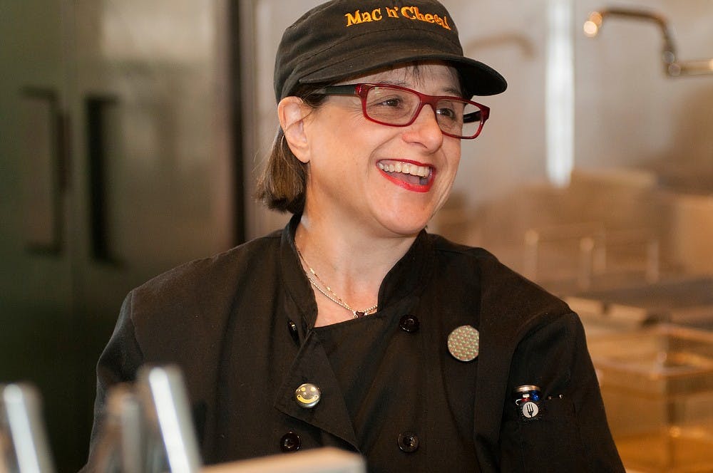 <p>Lorraine Platman, co-owner of Sweet Lorraine's Fabulous Mac N' Cheez, laughs while working the line Sept. 23, 2014, at Sweet Lorraine's Fabulous Mac N' Cheez. Raymond Williams/The State News</p>