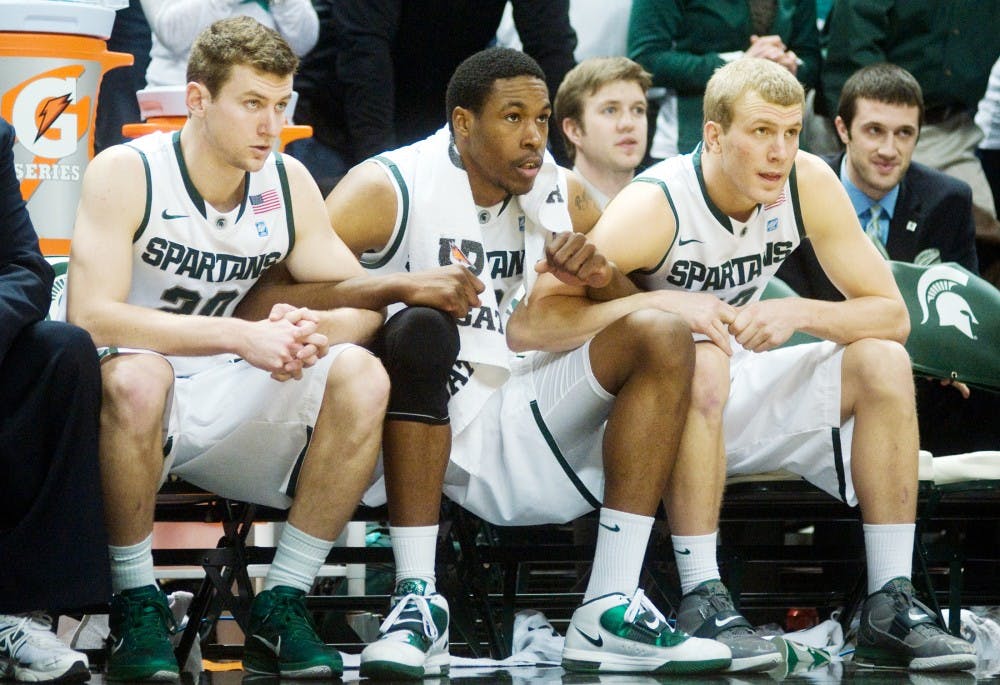 From left, senior guard Mike Kebler, junior forward Delvon Roe and junior guard Austin Thornton link arms with seconds left in the game as MSU trails Indiana, 79-78, Sunday at Breslin Center. A free throw kept the Spartans alive and took the game into overtime. MSU beat Indiana, 84-83. Kat Petersen/The State News