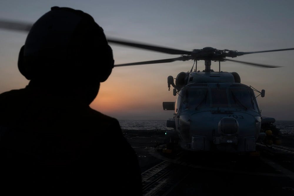 A U.S. Sailor assigned to Arleigh Burke-class guided-missile destroyer USS Delbert D. Black (DDG 119) directs an MH-60R Sea Hawk helicopter, attached to Helicopter Maritime Strike Squadron (HSM) 46, during a flight quarter evolution in the U.S. Central Command area of responsibility in support of Operation Epic Fury, Mar. 7, 2026. (U.S. Navy photo)