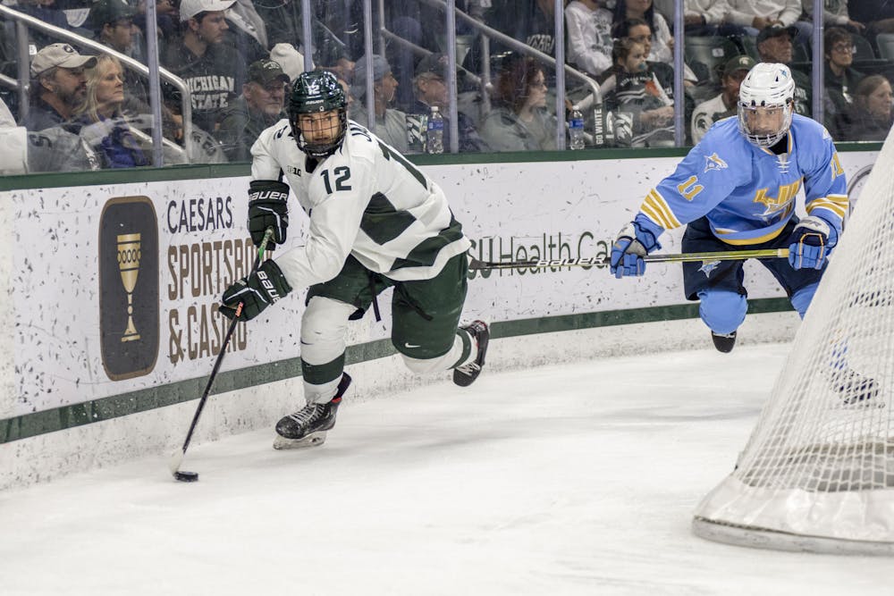<p>Graduate level forward Justin Jallen (12) moves with the puck during a game of hockey between MSU and Long Island University at Munn Ice Arena in East Lansing on Oct. 21, 2022. The Spartans won, 3-1.</p>