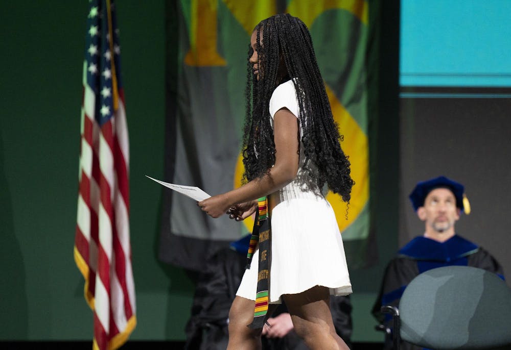 Arielle Anderson’s sister accepts her posthumous degree at The College of Natural Science graduate ceremony alongside Alexandria Verner’s godmother on Saturday, May 6, 2023 at the Breslin Center.