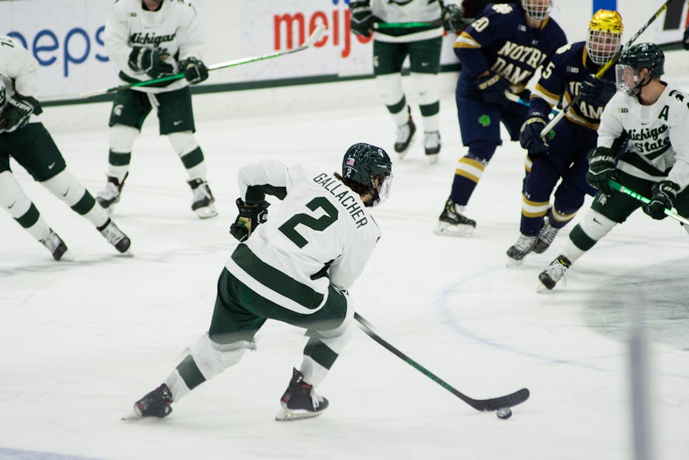Michigan State's Aiden Gallacher (2) defends the puck against Notre Dame on Feb. 26, 2021.