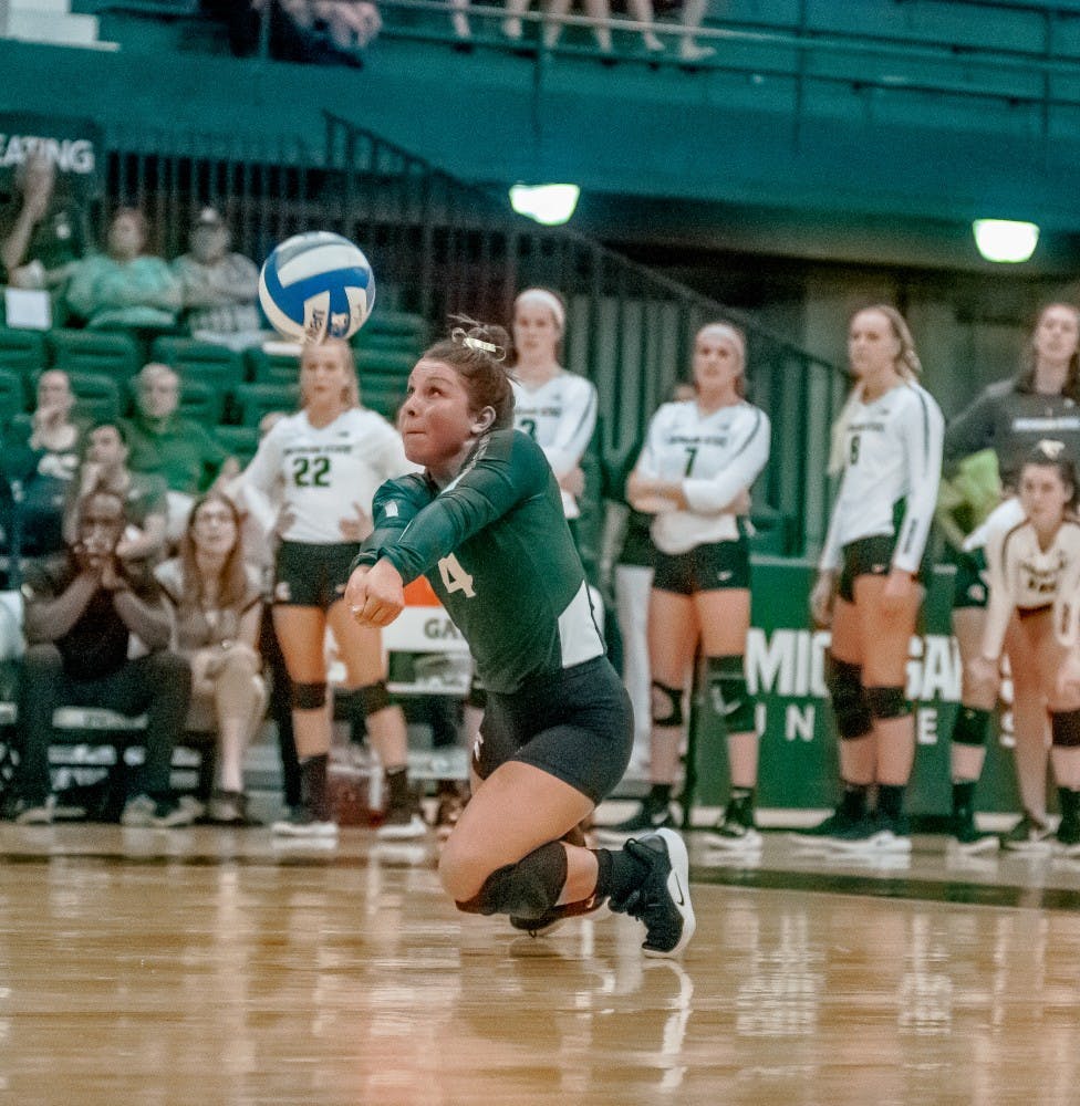 Sophomore defensive specialist and libero Jamye Cox (4) bumps the ball to her teammate during the game against Albany on Sept. 14, 2018 at Jenison Fieldhouse. The Spartans defeated the Great Danes, 3-0.