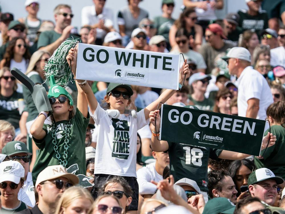<p>Three children hold up signs as they cheer for Michigan State University in Spartan Stadium in East Lansing, Mich., on Sept. 12, 2026.</p>