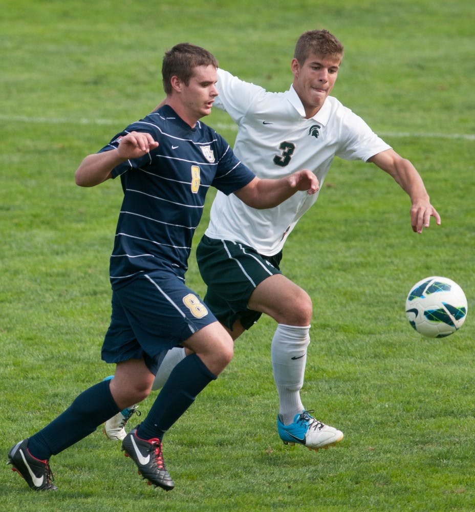 Marquette's forward Andy Huftalin tries to get to the ball with MSU's junior defender Kevin Cope in his way on Sunday, Sept. 16, 2012 at DeMartin Stadium at Old College Field. Marquette defeated MSU during overtime, 2-1. Justin Wan/The State News