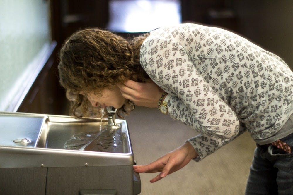 <p>Civil engineering junior Maria Milan drinks from a water fountain on October 14, 2017 at Williams Hall. The shut down wells did not provide water directly to taps on campus.</p>