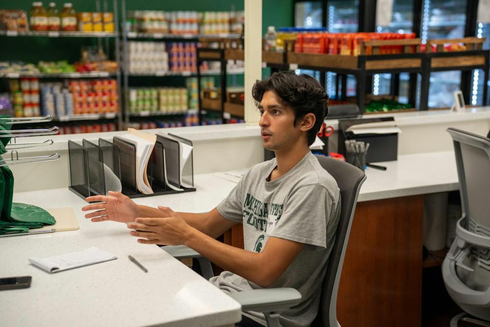 A Michigan State University Student Food Bank worker helps a student at the MSU Union in East Lansing, Mich., Thursday, Sept. 18, 2025.