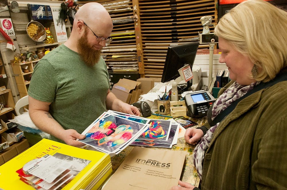 	<p>Kresge Art Store manager Casey Sorrow, left, and art education instructor Jill McKillips look at portraits of kids together on Dec. 2, 2013, in Kresge Art Center. Brian Palmer/The State News</p>