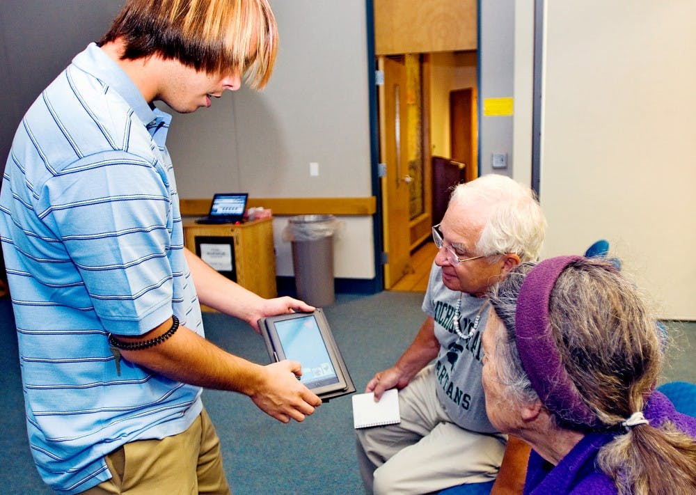 	<p>Library Technical Assistant Sam Roney, left, teaches East Lansing residents Henry Skopek and Elise Harvey how to download library books onto electronic reading devices such as the Nook seen here. East Lansing Public Library held this eBook clinic Monday evening free of charge and open to the public.</p>