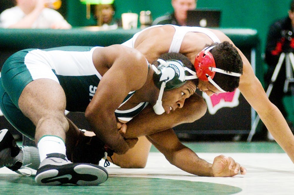 Senior 157-pounder Anthony Jones Jr. attempts to break the hold of Buckeye redshirt freshman Josh Demas. The Spartans fell to the Buckeyes 24-13 Sunday afternoon at Jension Field House. Anthony Thibodeau/The State News