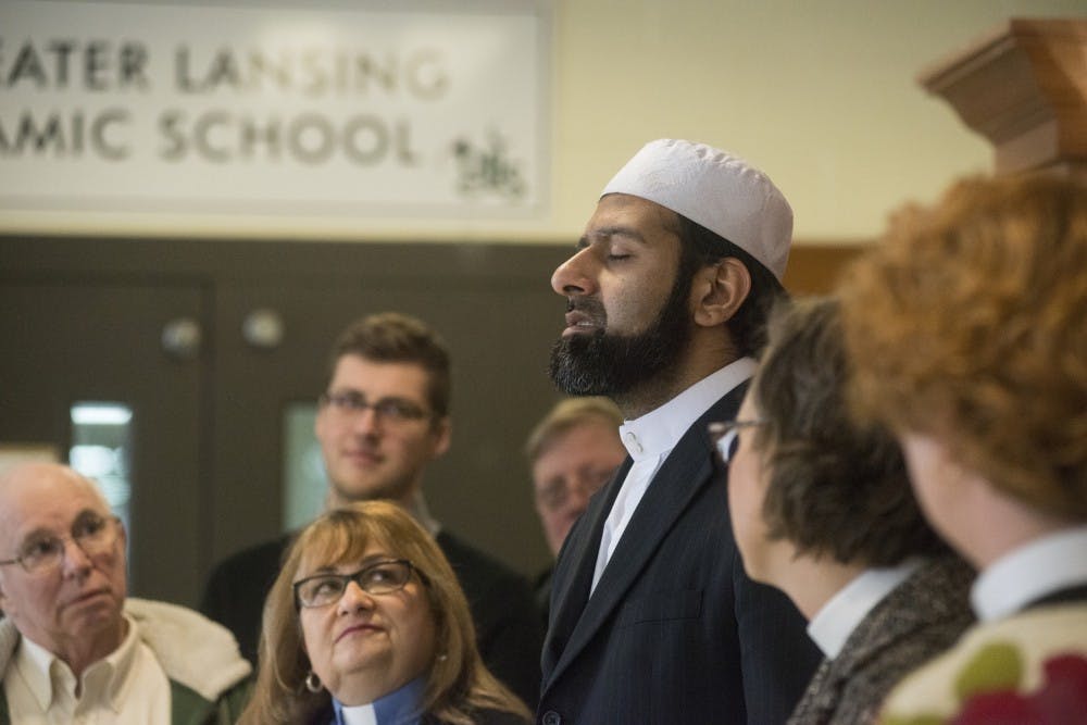 Members from different denominations around the Lansing community listen intently while Imam Sohail Chaudhry, center, chants a hymn from the Quran on Feb. 12, 2016 at The Islamic Center of East Lansing on 940 South Harrison Road.