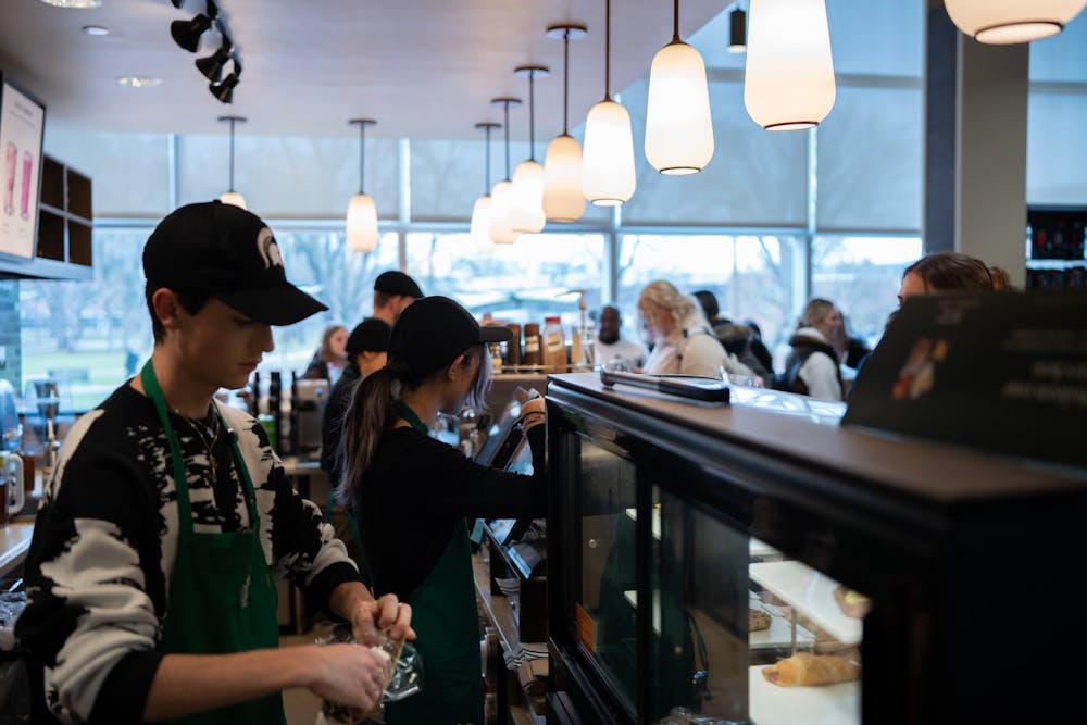 <p>Starbucks employees at Wells Hall make drinks and prepare food for a crowd of students on Thursday, Jan. 19, 2023. The popular location is set to move to MSU's Main Library before next fall semester, according to Associate Director of Retail Dining Gina Keilen.</p>