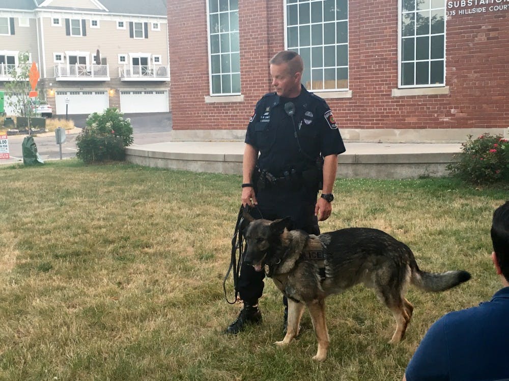<p>East Lansing Police Officer Erich Vedder conducts a K-9 demonstration&nbsp;with Diesel, a service dog, at the Moonlight Film Festival at Valley Court Park in East Lansing on July 14, 2016. The City of East Lansing hosts a free movie every Thursday in the summer until Aug. 11, 2016.</p>