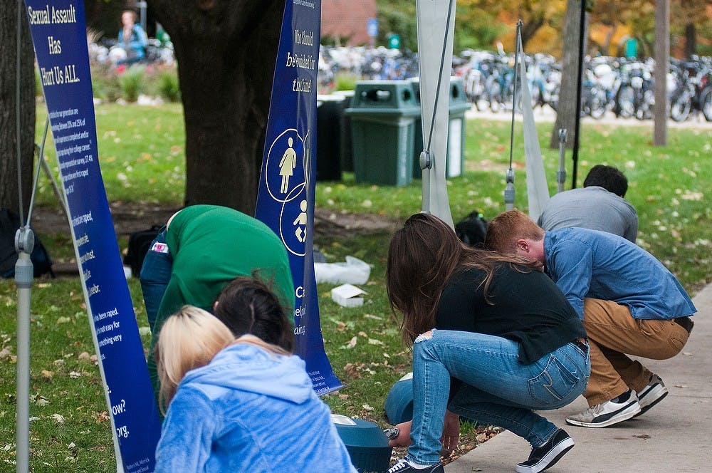 <p>Representatives from the Michigan State Students for Life organization and Students for Life of America set up banners on Oct. 14, 2014, at the People's Park behind Wells Hall. Representatives addressed issues of the prevention of sexual assault through the We Care Project. Aerika Williams/The State News</p>