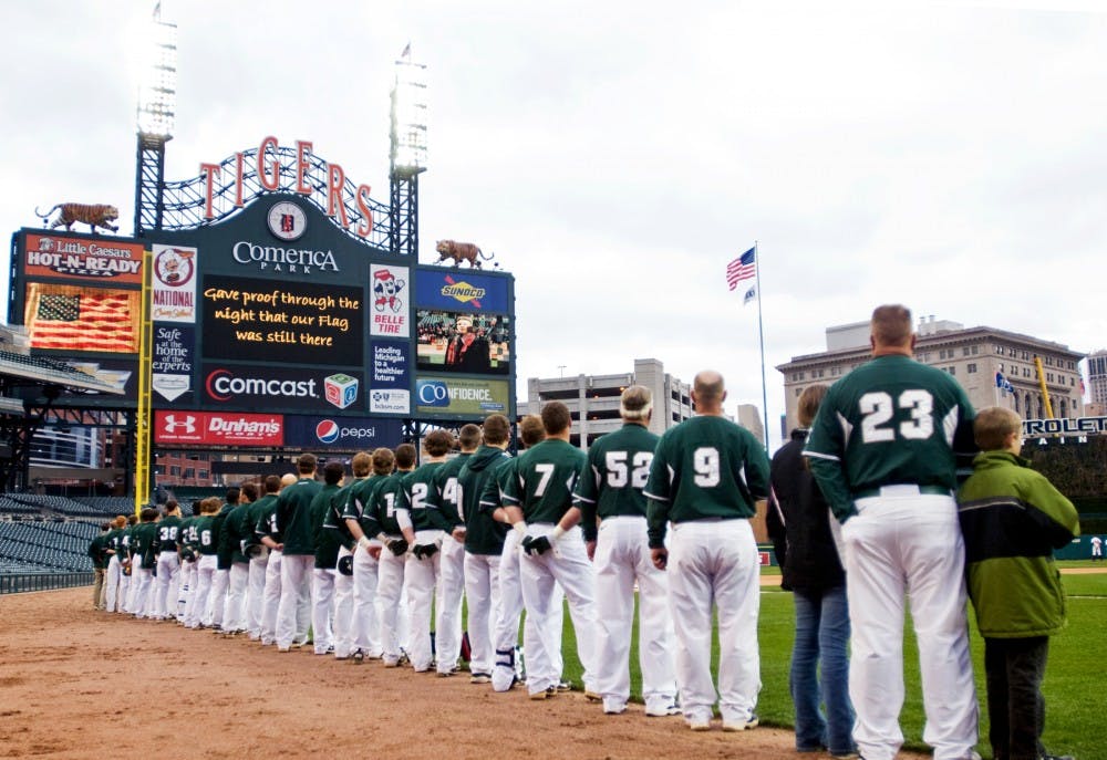 The Spartans look toward the flag as the national anthem is sung Wednesday at Comerica Park in Detroit. The Spartans will take on the Central Michigan Chippewas at the Detroit Tigers' home stadium on Tuesday.