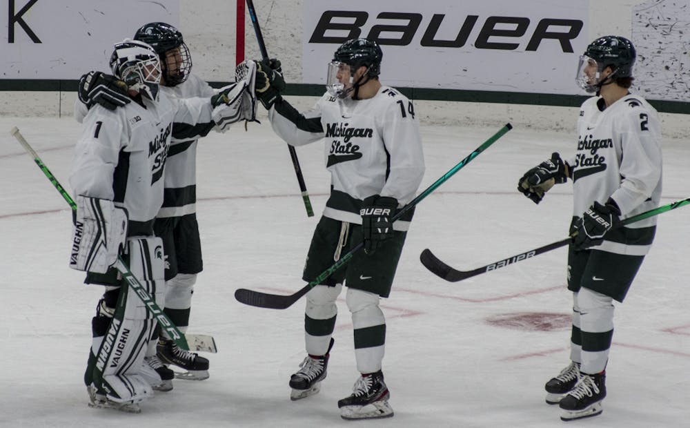 <p>Junior left wing Adam Goodsir (14) congratulates his teammates after MSU won the two-game series against Arizona State. The Spartans triumphed against the Sun Devils, 2-0, on Nov. 20, 2020.</p>