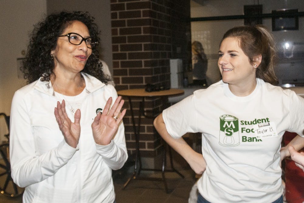 Lupe Izzo instructs psychology junior Taylor Bean on volunteering during the MSU Rebounders Club Annual Food Drive on Jan. 29, 2017 at Breslin Center. Lupe Izzo has planned this event in coordination with the MSU Student Food Bank for 23 years and Taylor Bean is an employee of the food bank. The proceeds and food raised from the fundraiser will be split evenly between the MSU Student Food Bank and Greater Lansing Food Bank. 