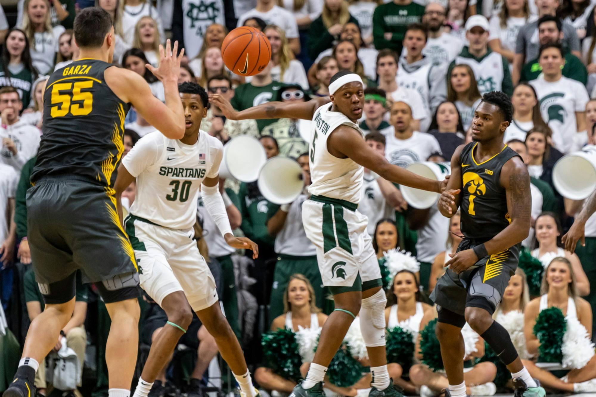 <p>Iowa center Luka Garza (5) catches a pass from Iowa guard Joe Toussaint (1) on Feb. 25, 2020.</p>