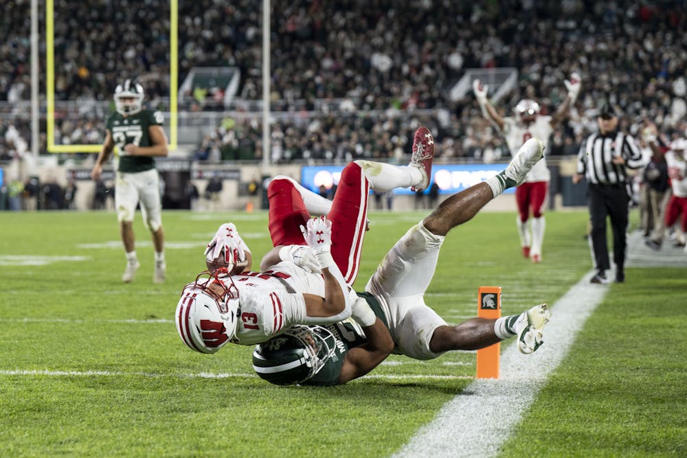 Senior defensive end Kris Bogle (2) tackles junior wide reciever Chimere Dike (13) in the endzone during the game against Wisconsin on October 15, 2022. The Spartans beat the Badgers 34 to 28.