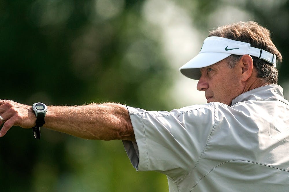 <p>Head coach Mark Dantonio gives pointers during practice drills Aug. 8, 2014, at the practice field outside Duffy Daugherty Football Building. The football season kicks off on Aug. 29, with a game against Jacksonville State. Jessalyn Tamez/The State News</p>