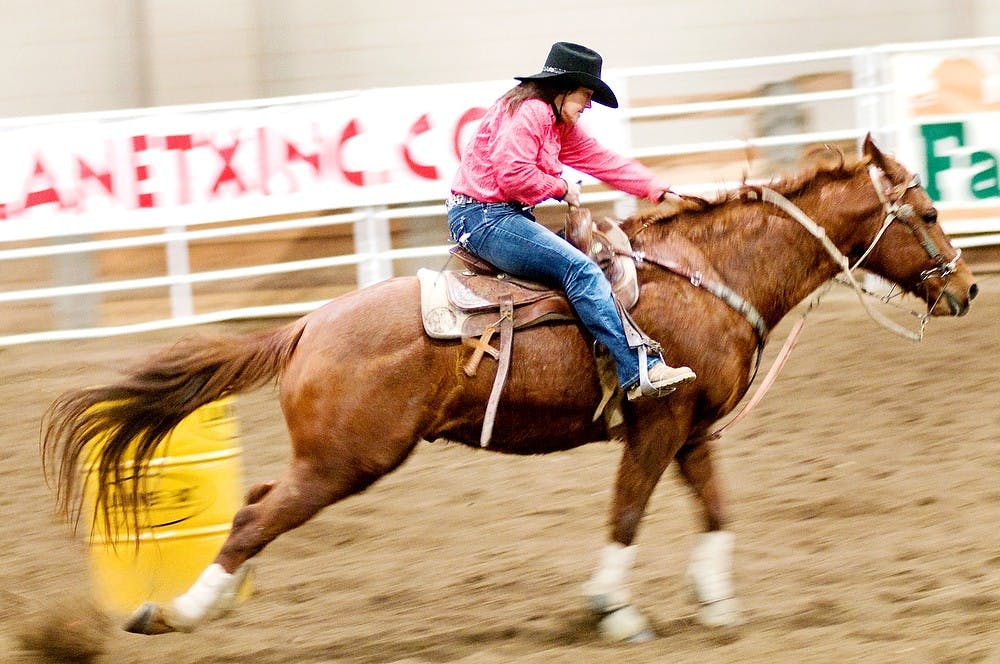 	<p>Barrel racer Lori Wilcox of Sodus, Mich., cuts a tight corner Friday, Feb. 19, 2012, at the Pavilion, 4301 Farm Lane. In barrel racing, the rider and horse must take two turns to one side and one turn to the other around three barrels. State News File Photo</p>