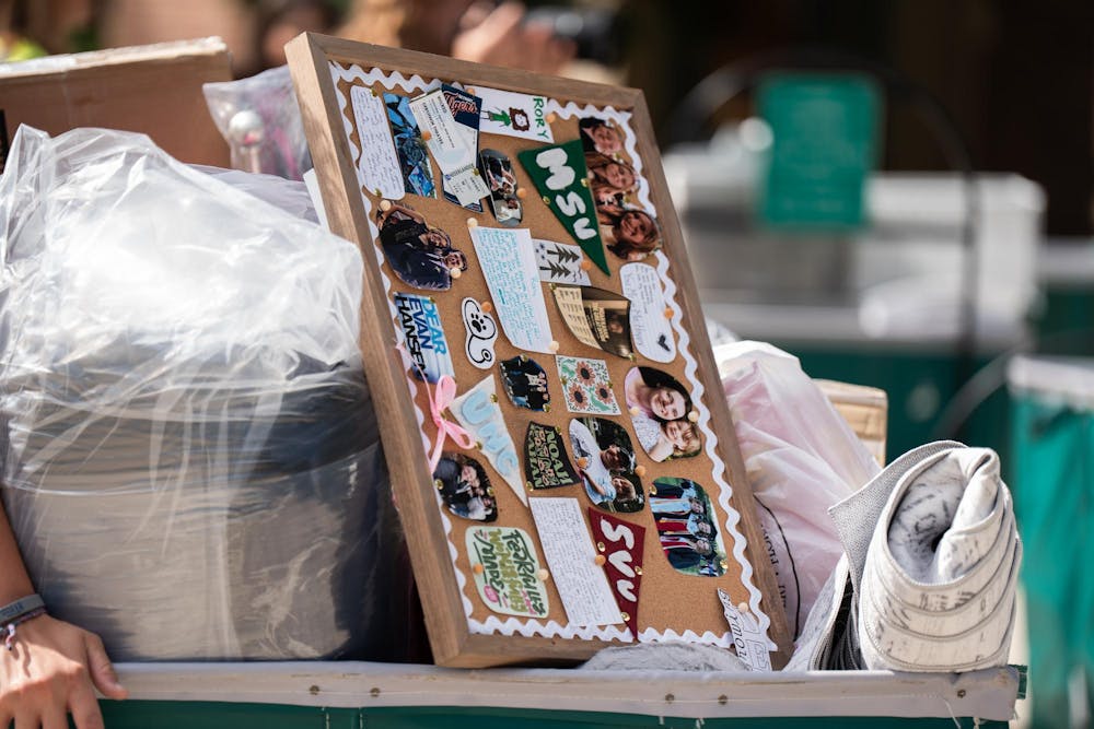 <p>A student's move-in cart is adorned with a sentimental cork board among dorm essentials during fall move-in at Yakeley Hall in East Lansing, Mich., on Aug. 25, 2026.</p>