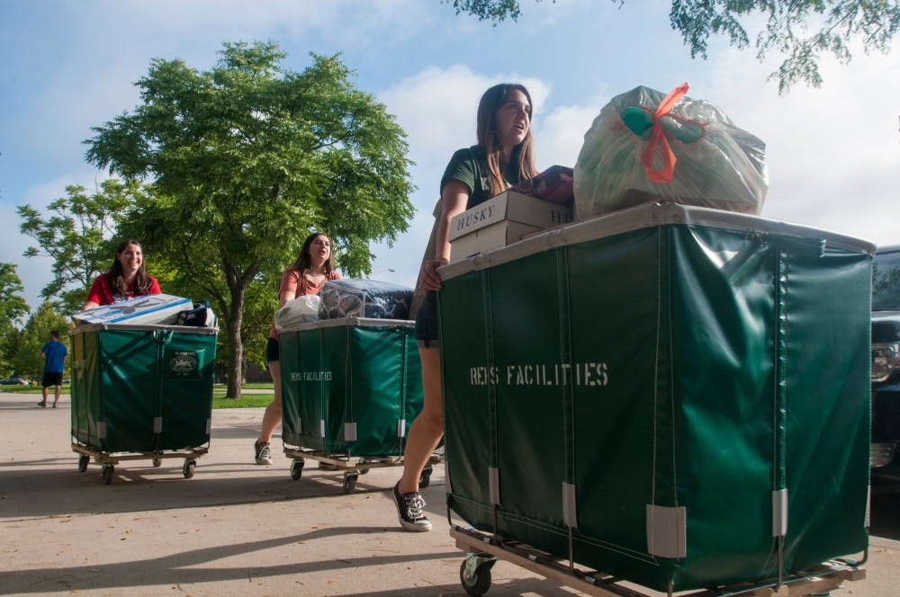 Veterinary medicine freshman Kera Conroy, right, pushes her belongings ahead of her mother and sister on Aug. 28, 2016, at Brody Complex. Conroy and her family traveled from Kalamazoo, Michigan, to take part in move-in day for first year students.