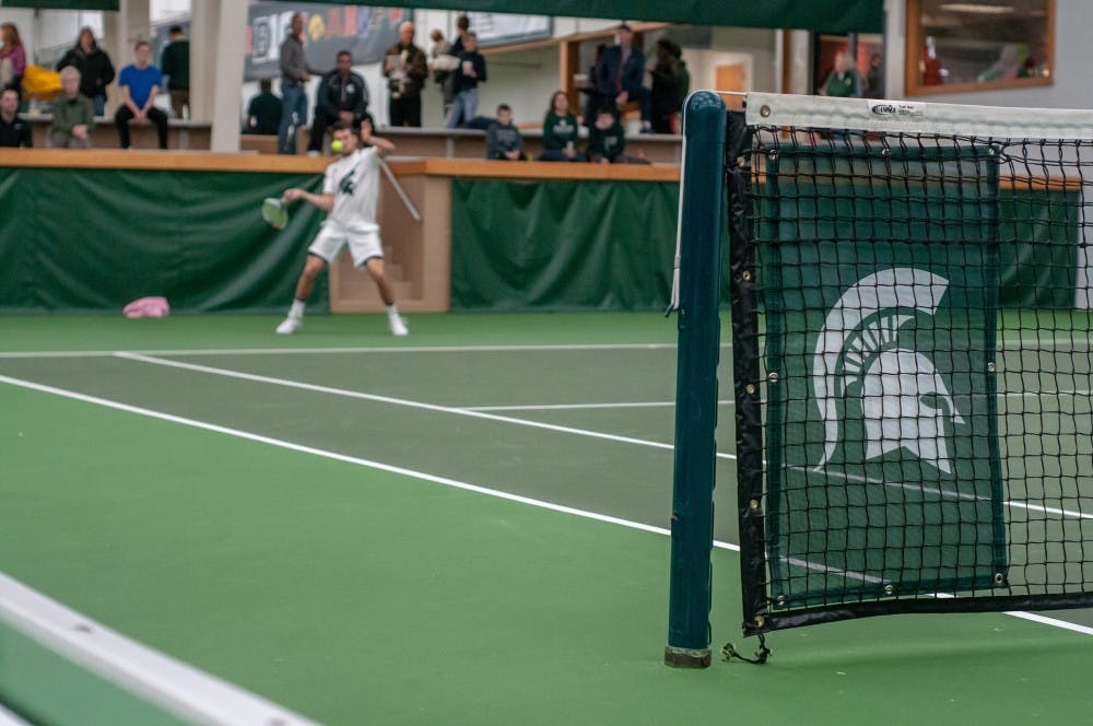 Sophomore Ivan Rakic hits the ball during a singles match at the MSU Tennis Center on Jan. 12, 2019.