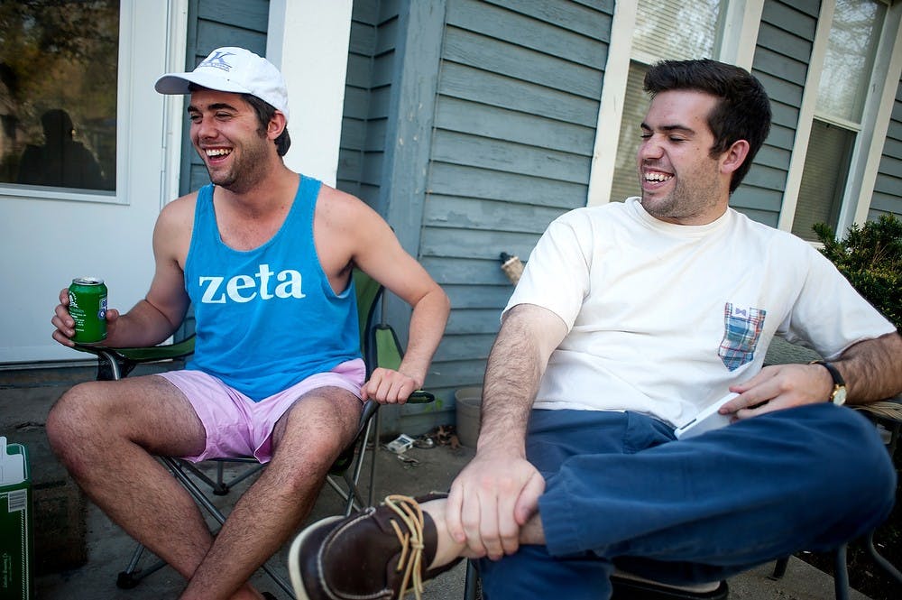 	<p>From left, recent graduates Eric Brooks and Geno Battista share a laugh with their friends May 15, 2013, on the front porch of their house on M.A.C. Avenue. According to city ordinances, residents must pick up party litter from the night before in order to avoid a citation. Justin Wan/The State News</p>