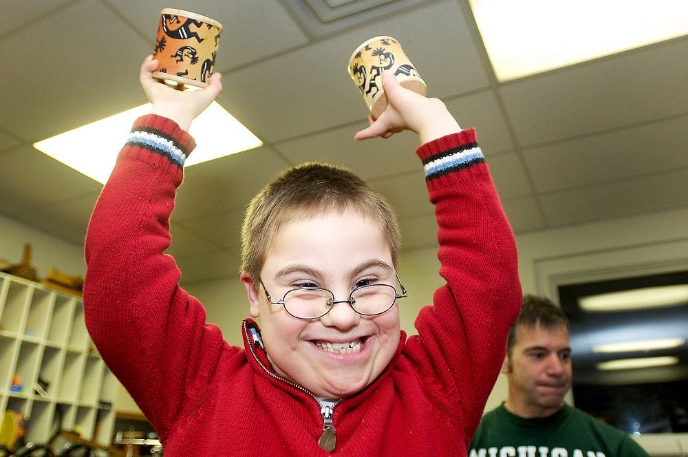 	<p>East Lansing resident Joe DeRogatis-Frilingos, 9, holds up shaker instruments as Christmas music plays in the background during the Together…Let&#8217;s Jam! community pop-up concert on Wednesday, Dec. 5, 2012, at the <span class="caps">MSU</span> Community Music School. The <span class="caps">MSU</span> Community Music School hosts these meetings once a month that are sponsored by the Capital Area Down Syndrome Association. Katie Stiefel/ State News</p>