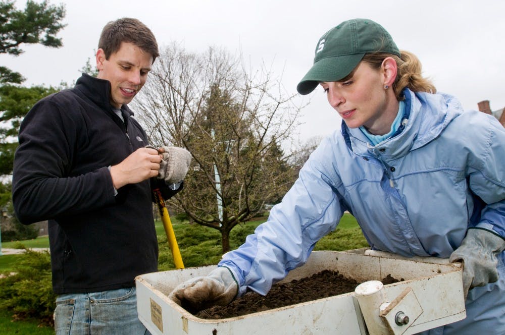 	<p>Graduate students Jane Wank-Miler, right, and doctoral student Chris Stawski take a closer look at objects they dug up Friday morning outside Cowles House. </p>