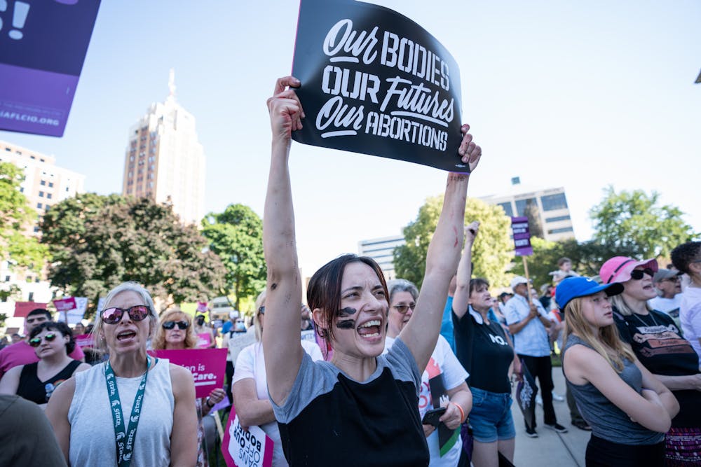 <p>Victoria Moshier, a Lansing resident, protests the overturning of Roe v. Wade outside of the Michigan State Capitol building on June 24, 2022.</p>