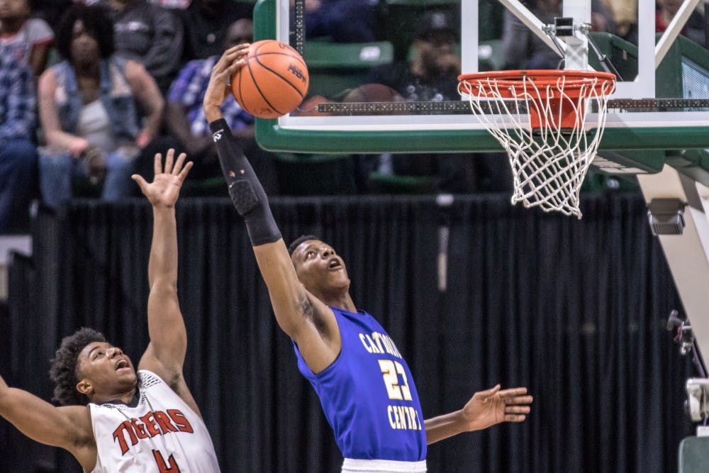 Grand Rapids Catholic Central senior forward Marcus Bingham Jr. (23) catches a pass at the rim during Benton Harbor's 65-64 overtime win against Grand Rapids Catholic Central in the Class B boys basketball state final on March 24, 2018 at Breslin Center in East Lansing.