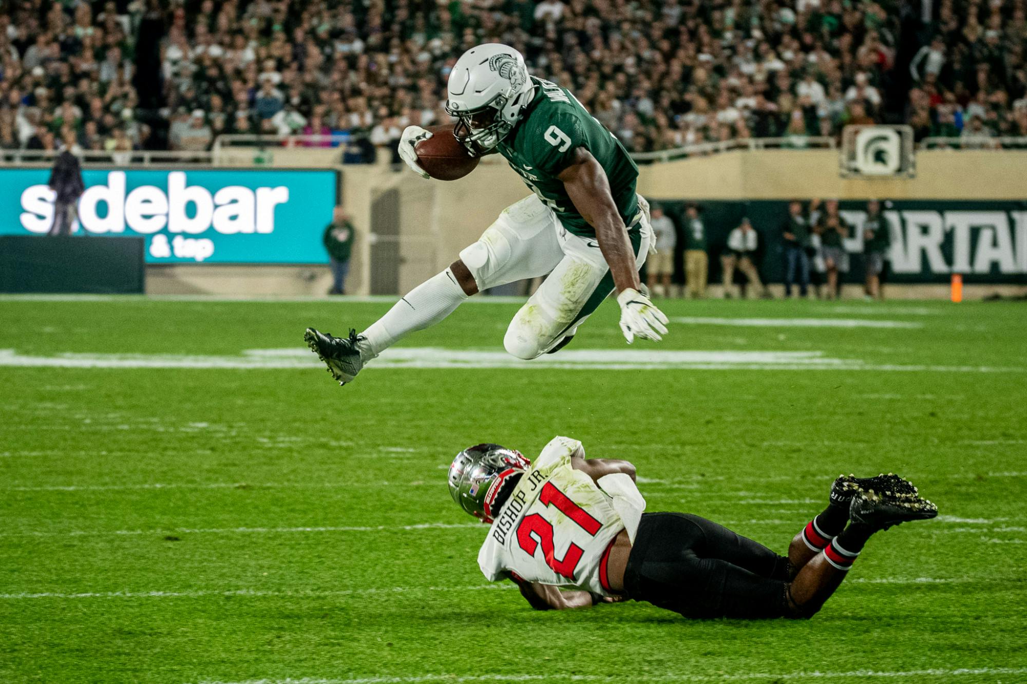 <p>Junior running back Kenneth Walker III hurdles a Western Kentucky defender on his way to the end zone during the Spartans&#x27; homecoming game on Oct. 2, 2021.</p>