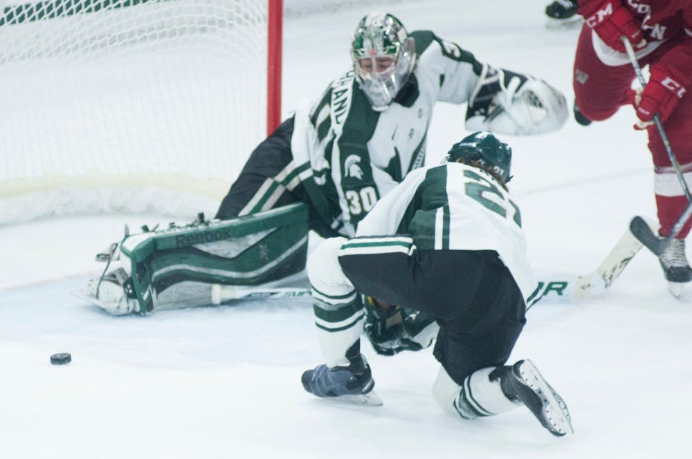 <p>Junior goaltender Jake Hildebrand stops a goal March 6, 2015, during the game against Wisconsin at Munn Ice Arena. The Spartans defeated the Badgers 3-0. Kennedy Thatch/The State News</p>