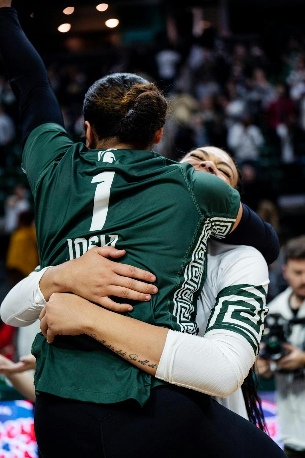 Michigan State senior defensive specialist Nalani Iosia (1) hugs her teammate after winning against University of Michigan at the Breslin Center on Nov. 15, 2024.