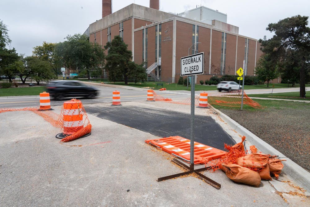 A car drives over a temporarily repaired sinkhole on Service Rd near the south end of MSU's campus on Thursday, Sept. 28, 2023. MSU officials closed the road after a sinkhole formed Wednesday night.