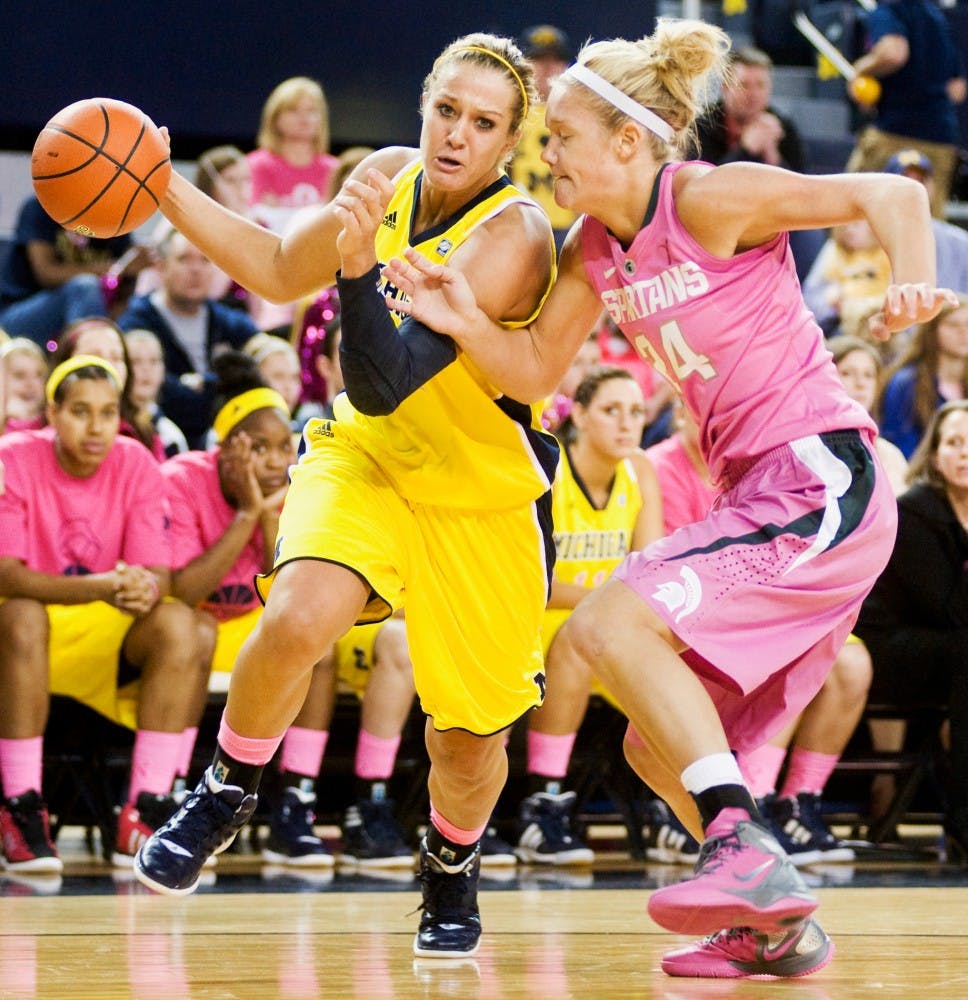 Michigan guard/forward Jamillya Hardley drives down to the baseline with redshirt junior forward Courtney Schiffauer keeping the pressure on her. The Spartans defeated the Michigan Wolverines with a last minute 2-point field goal, 65-63, Sunday afternoon at Crisler Arena. Justin Wan/The State News