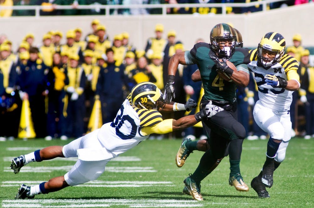 Junior running back Edwin Baker evades the Michigan defense Saturday at Spartan Stadium. The Spartans defeated the Michigan Wolverines 28-14. Matt Radick/The State News