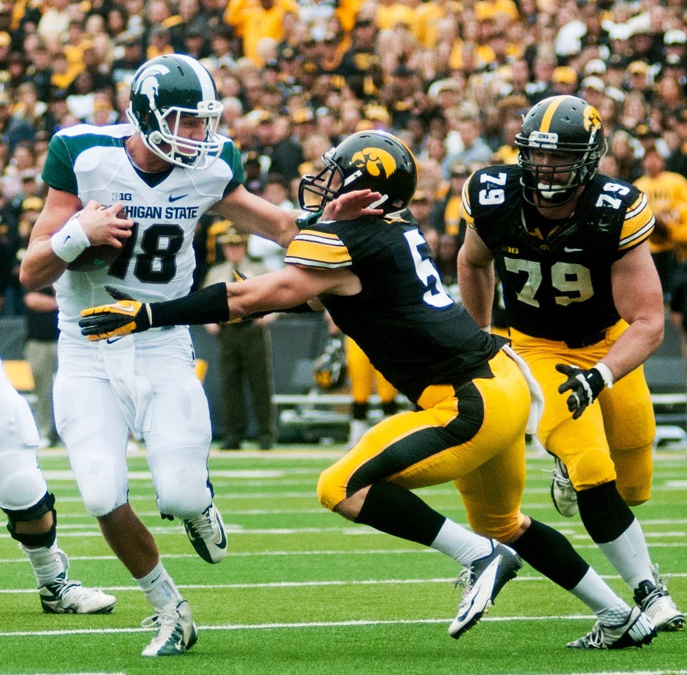 	<p>Sophomore quarterback Connor Cook tries to push away Iowa defensive back Tanner Miller, Oct. 5, 2013, in Iowa City, Iowa. The Spartans defeated the Hawkeyes, 26-14. Danyelle Morrow/The State News</p>
