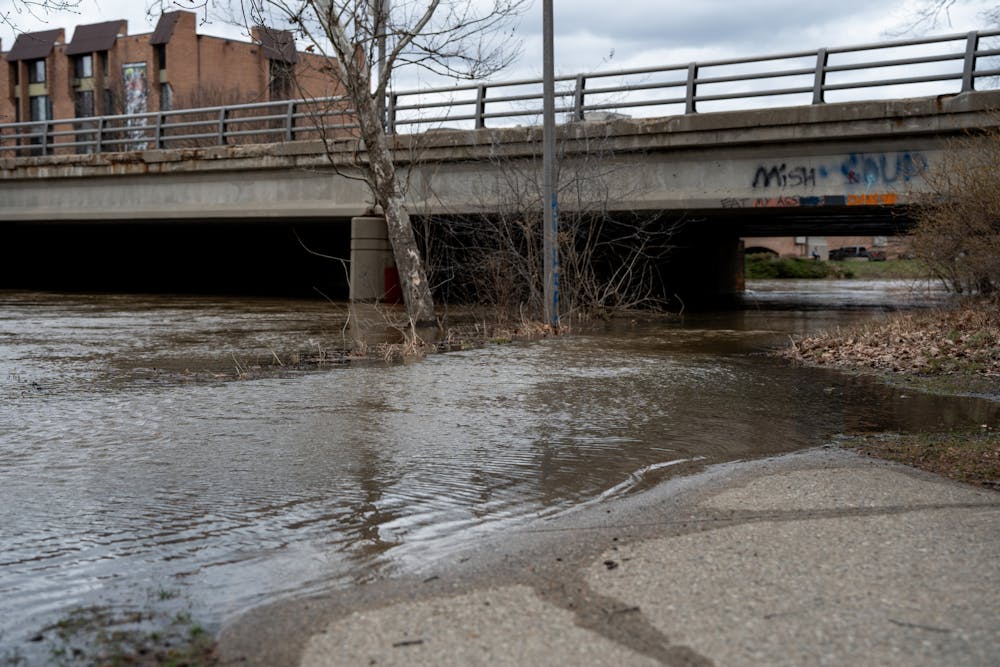 The Red Cedar River floods the sidewalks after heavy rainfall on campus on April 5, 2023. 