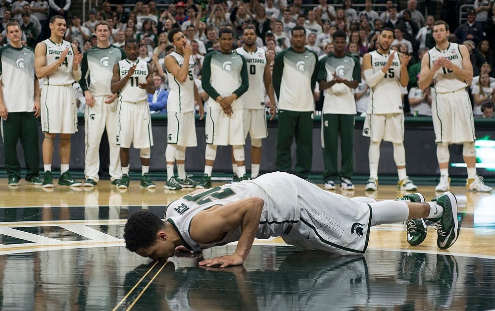 <p>Senior guard Travis Trice kisses the court floor Mar. 4, 2015, during the senior night celebration at the game against Purdue at Breslin Center. Kissing the floor at the end of the last home game is a tradition for seniors. Emily Nagle/The State News</p>
