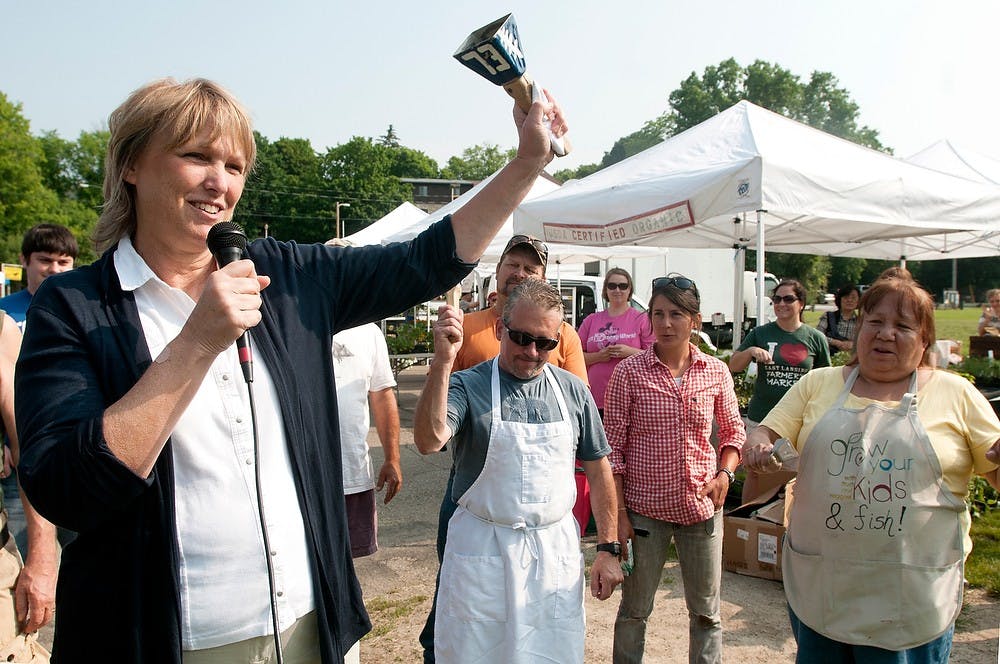 <p>East Lansing Mayor Diane Goddeeris rings the opening bell at the East Lansing Farmer's Market at Valley Court Park June 9, 2013. The farmer's market will happen every sunday from June 9, 2013 to October 27, 2013.  Weston Brooks/The State News</p>