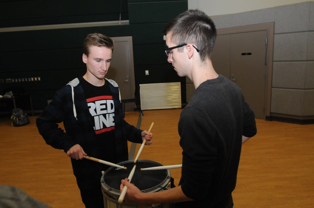Biochemistry freshman Connor Riegal, left, demonstrates his technique for a student auditioning for a drummer position with the Michigan State drumline in the future, on Jan. 12, 2017 at Demonstration Hall.