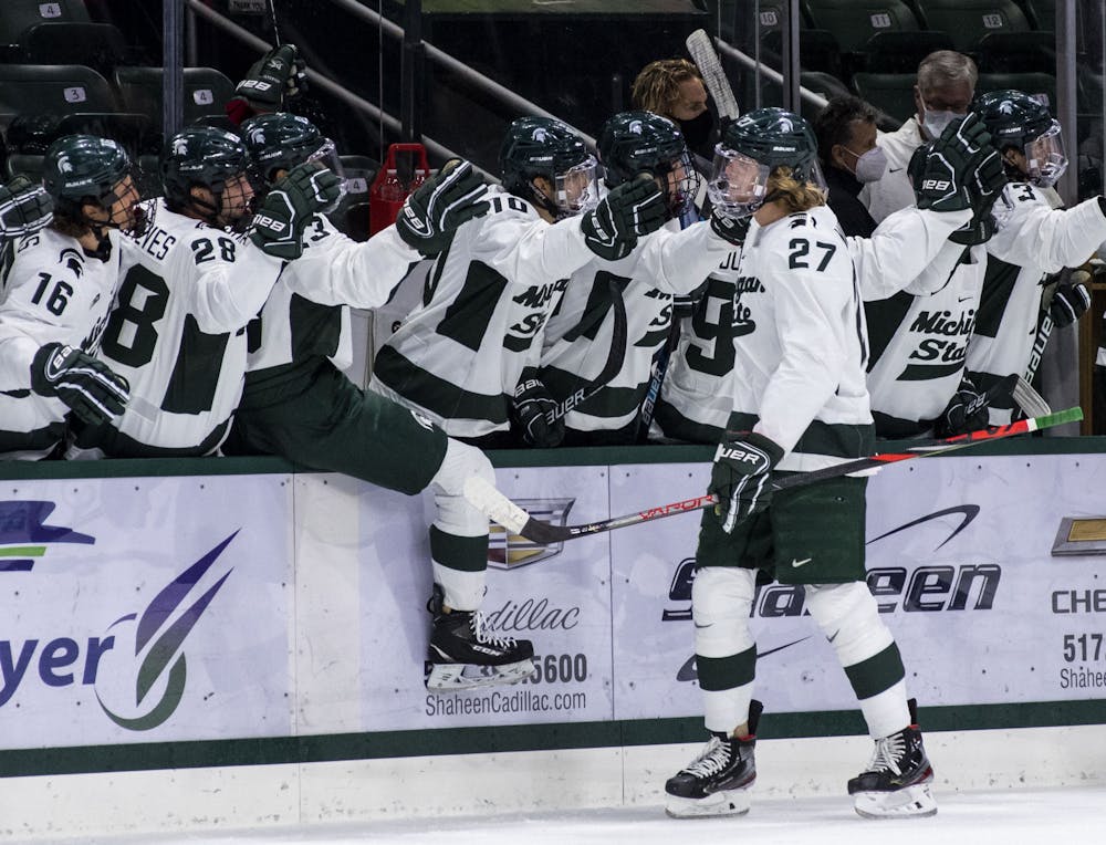 <p>Players on the bench congratulate junior center Mitchell Mattson (27) on his first Spartan career goal in the first period. The Spartans triumphed against the Sun Devils, 2-0, on Nov. 20, 2020.</p>