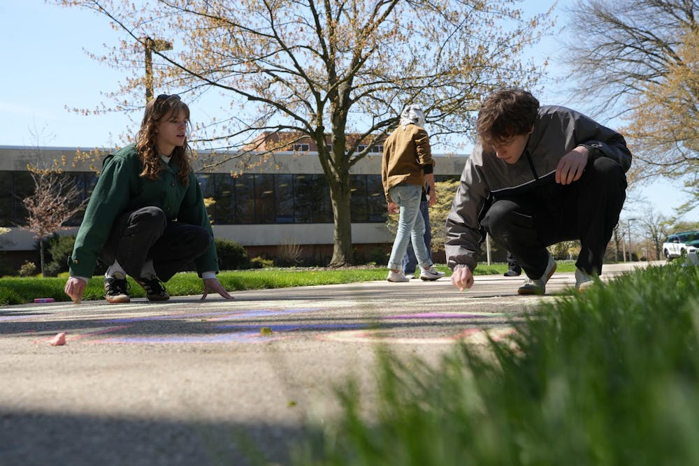 Two students draw on the pavement with chalk during a Gaza solidarity encampment in People’s Park on April 25, 2024.