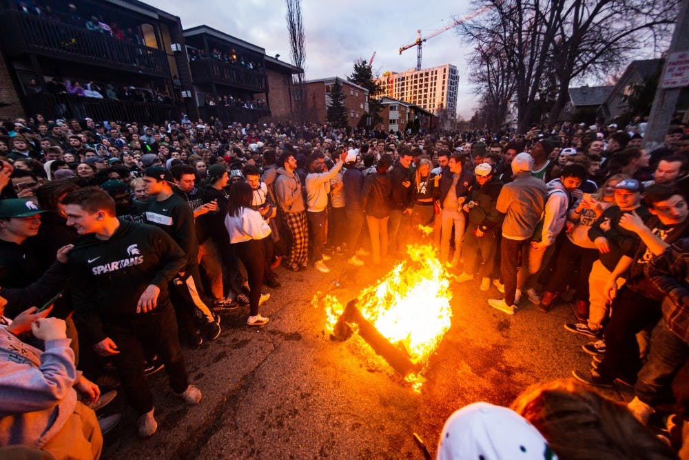 Students stand around a fire at Cedar Village Apartments after MSU's victory over Duke in the Elite Eight on March 31, 2019.