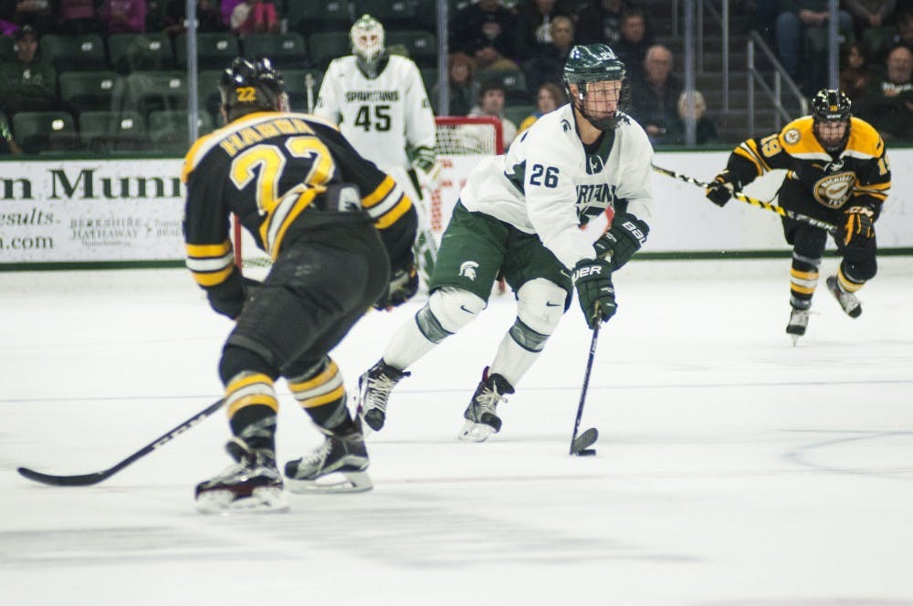 Senior left wing Villiam Haag (26) handles the puck while being covered by Michigan Tech defenseman Shane Hanna (22) in the game against Michigan Tech on Nov. 4, 2016 at Munn Ice Arena. The Spartans defeated the Huskies in overtime, 3-2.