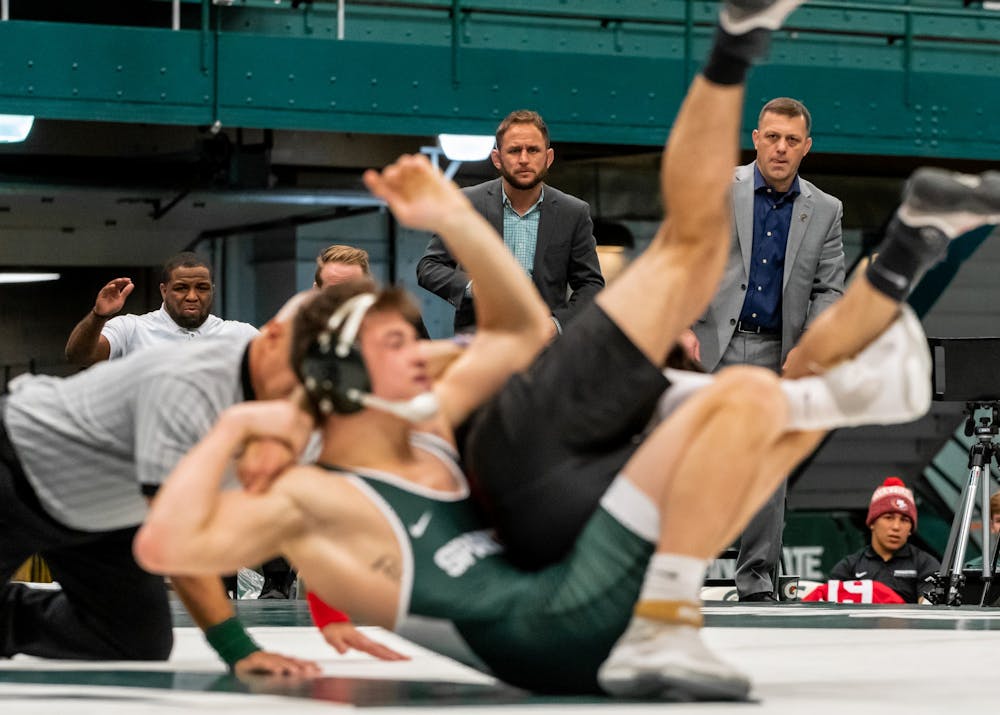 <p>Michigan State Head Coach Roger Chandler (right), Assistant Coach Chris Williams (center), and Volunteer Assistant Coach Anthony Jones (left) look on as freshman Layne Malczewski wrestles Maryland’s Jonathan Spadafora. Malczewski defeated Spadafora, 3-0. The Spartans defeated the Terrapins, 36-0, at Jenison Field House on Jan. 19.</p>