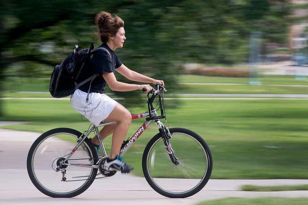 <p>A biker makes her way across campus Sept. 2, 2014, near Beaumont Tower. Julia Nagy/The State News</p>